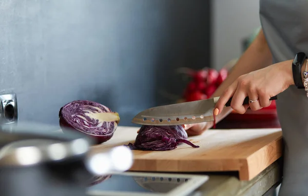 Yeni mutfakta yemek pişiren kadın sebzelerle sağlıklı yemekler yapıyor. — Stok fotoğraf