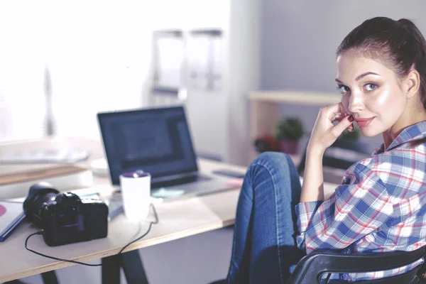 Femme photographe assise sur le bureau avec ordinateur portable — Photo