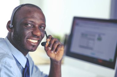 Kulaklıklı Afro-Amerikan işadamı laptopuyla çalışıyor.