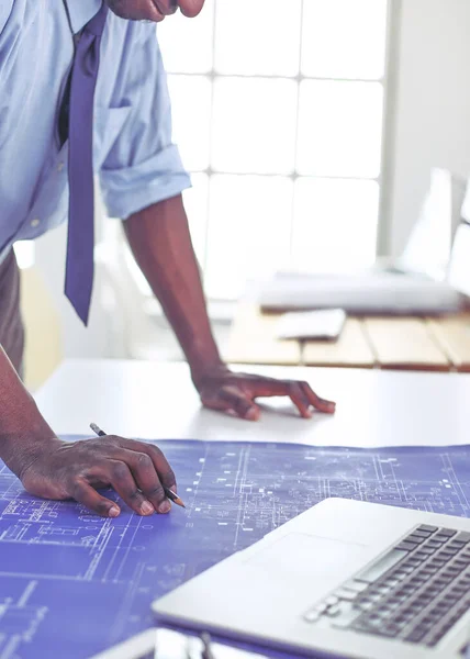 Arquitecto afroamericano trabajando con computadoras y planos en la oficina —  Fotos de Stock