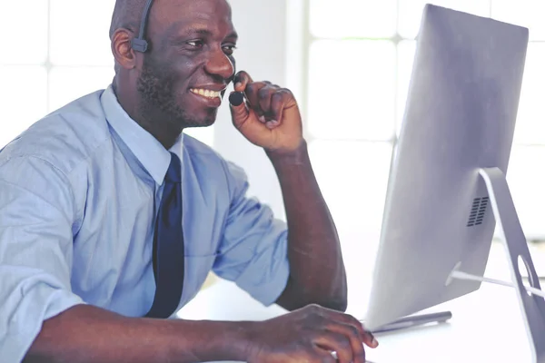 Homme d'affaires afro-américain sur casque de travail sur son ordinateur portable — Photo