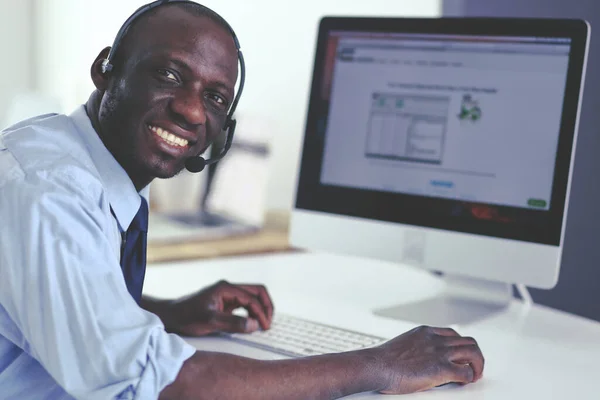 African american businessman on headset working on his laptop — Stock Photo, Image