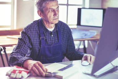 Ofisteki çizim masasında çalışan mimar