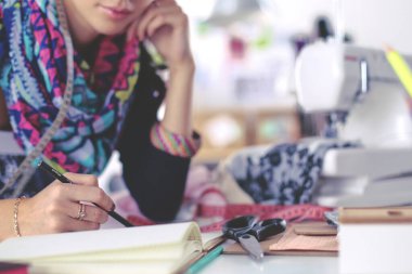 Giysi tasarımcısı kağıt üzerinde kıyafet deseni tasarlıyor