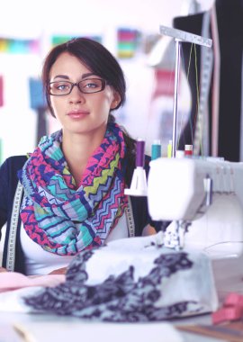 Çalışırken dikiş diken genç bir kadın.