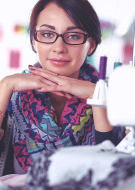 Çalışırken dikiş diken genç bir kadın.