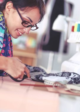 Çalışırken dikiş diken genç bir kadın.