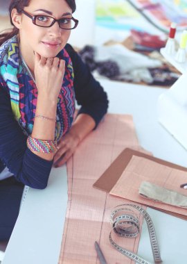 Genç terzi kâğıt üzerinde kıyafet deseni tasarlıyor.