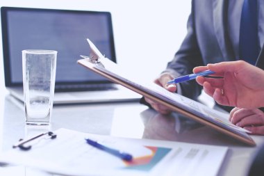 İş adamları iş toplantısında, ofiste oturup tartışıyorlar.