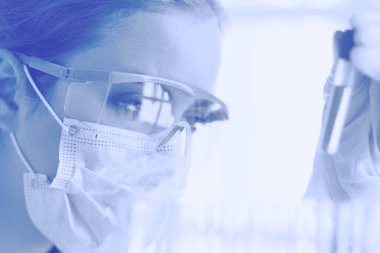 Modern laboratuvar veya hastanede plastik tıbbi tüplerle çalışan araştırmacı, doktor, bilim adamı veya laboratuvar asistanı