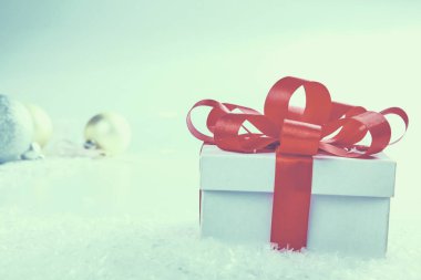 Kırmızı kurdeleli beyaz hediye kutusu.