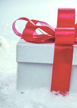 Kırmızı kurdeleli beyaz hediye kutusu.