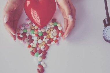 Masada kırmızı kalbi ve steteskopu olan kardiyolog.