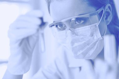 Modern laboratuvar veya hastanede plastik tıbbi tüplerle çalışan araştırmacı, doktor, bilim adamı veya laboratuvar asistanı