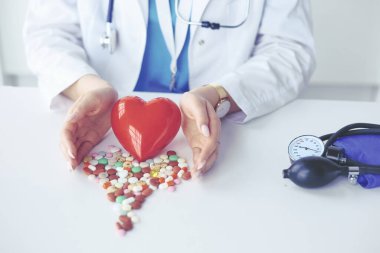 Masada kırmızı kalbi ve steteskopu olan kardiyolog.