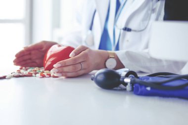 Masada kırmızı kalbi ve steteskopu olan kardiyolog.