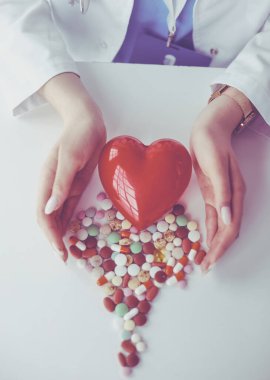 Masada kırmızı kalbi ve steteskopu olan kardiyolog.