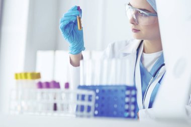 Laboratuvar asistanı bir kan örneğini analiz ediyor.