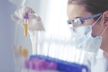 Laboratuvarda sıvı yeşil çözeltiye bakan bir tıbbi veya bilimsel araştırmacı ya da doktor