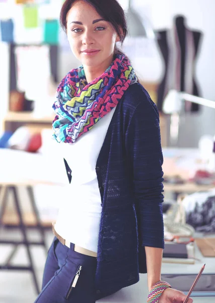Schöne Modedesignerin steht im Atelier — Stockfoto