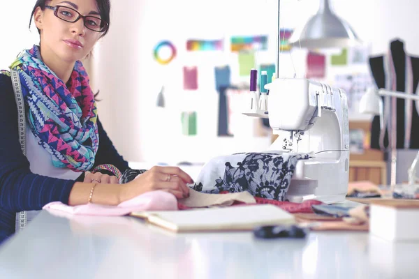 Jovem costureira projetando padrão de roupas em papel — Fotografia de Stock