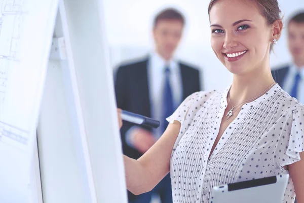 Zakenvrouw schrijven op flipchart terwijl het geven van presentatie aan collega 's in het kantoor — Stockfoto