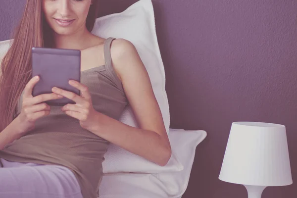 Vrouw die op de vloer zit met een digitale tablet — Stockfoto