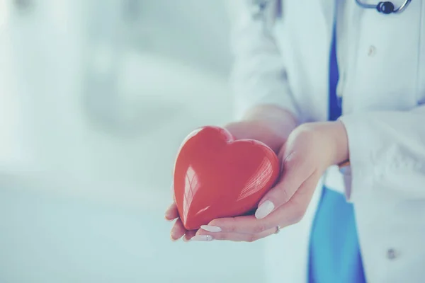 심장을 들고 있는 청진기를 가지고 있는 여자 의사, 밝은 배경 — 스톡 사진