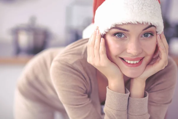 Mujer joven sonriente en la cocina, aislada en el fondo de Navidad —  Fotos de Stock