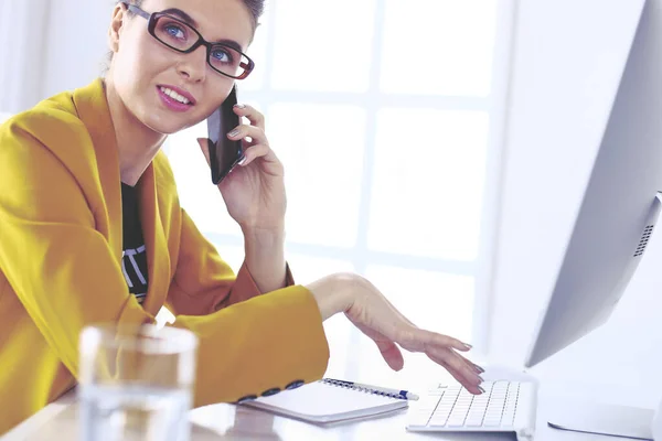 Zakenvrouw concentreert zich op het werk, met behulp van computer en mobiele telefoon in het kantoor — Stockfoto