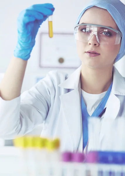 女医生女性医学或科学研究人员或女医生，在实验室里检查有清晰溶液的试管 — 图库照片