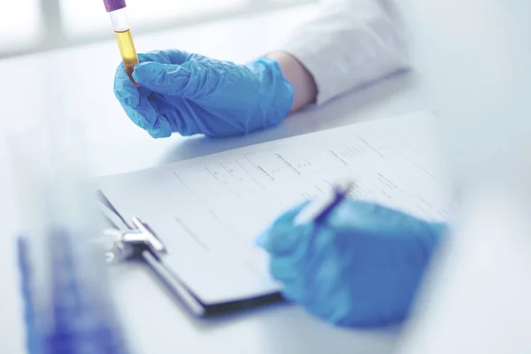 Woman researcher is surrounded by medical vials and flasks, isolated on white background — Stock Photo, Image