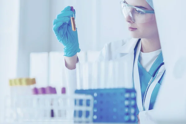 Assistente de laboratório analisando uma amostra de sangue — Fotografia de Stock