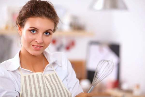 Sorridente giovane donna in piedi in cucina — Foto Stock