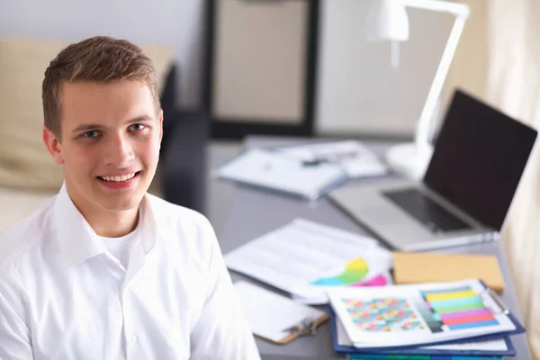 Young businessman with folder sitting in the office — Stock Photo, Image