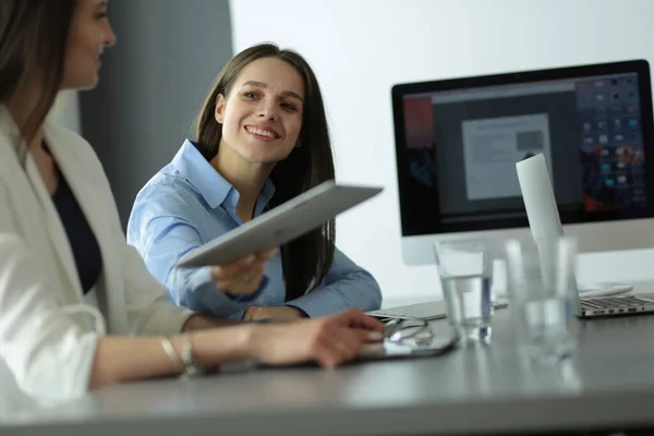 Zwei Bürokolleginnen sitzen auf dem Schreibtisch — Stockfoto