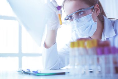 Modern laboratuvar veya hastanede plastik tıbbi tüplerle çalışan araştırmacı, doktor, bilim adamı veya laboratuvar asistanı.