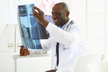 Tablet bilgisayarlı siyahi bir doktor hastanede bekliyor.