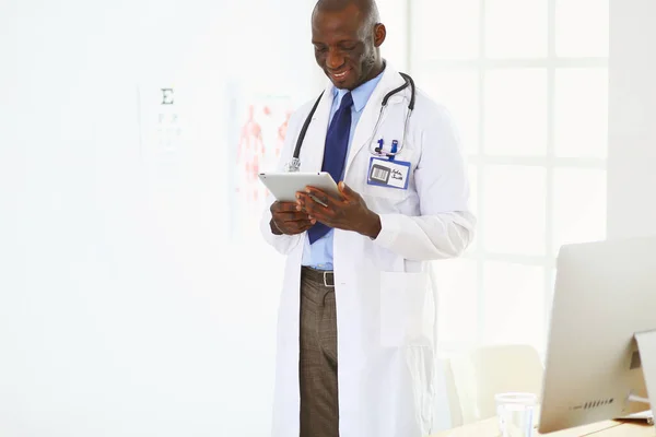 Male black doctor worker with tablet computer standing in hospital — Stock Photo, Image