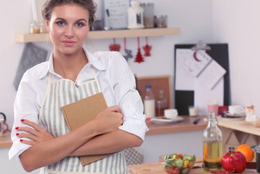 Mutfakta gülümseyen genç bir kadın, Noel arkaplanında soyutlanmış.