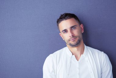 Genç iş adamı beyaz arka planda tek başına duruyor.