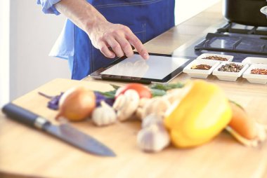 Adam ev mutfağında lezzetli ve sağlıklı yemekler hazırlıyor.