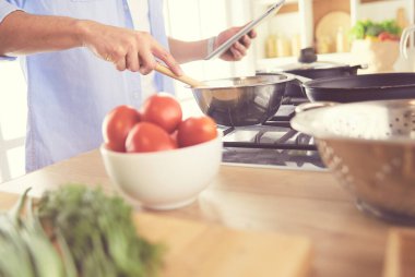 Adam ev mutfağında lezzetli ve sağlıklı yemekler hazırlıyor.