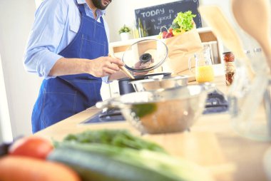 Adam ev mutfağında lezzetli ve sağlıklı yemekler hazırlıyor.