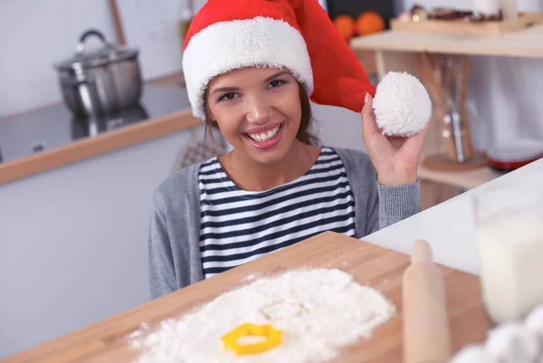 Lykkelig ung kvinde smilende glad for at have det sjovt med juleforberedelser iført Santa hat - Stock-foto