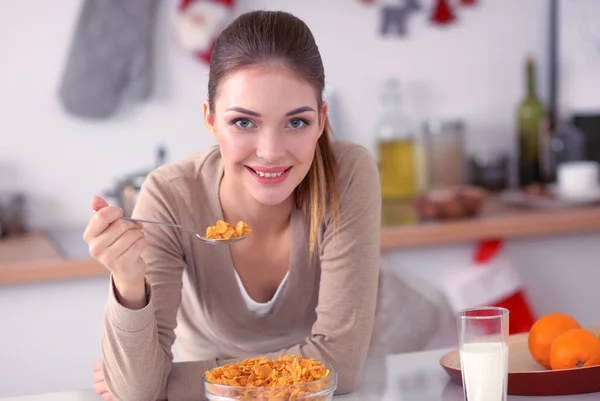 Sorrindo mulher atraente tomando café da manhã no interior da cozinha — Fotografia de Stock
