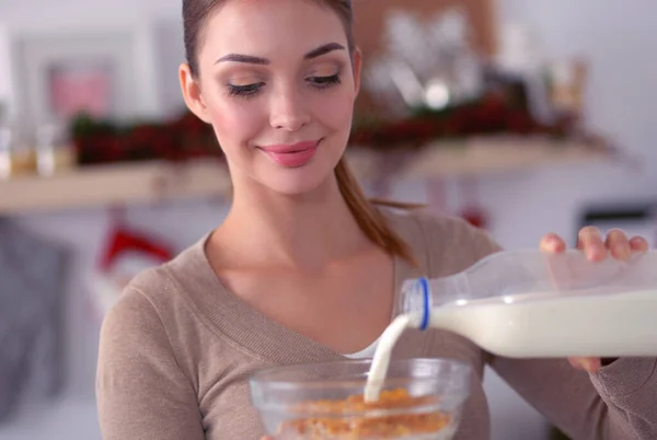 Mujer atractiva sonriente desayunando en el interior de la cocina — Foto de Stock