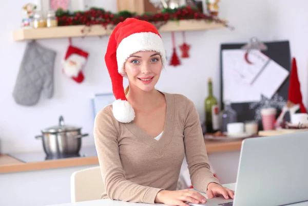 Mutfakta gülümseyen genç bir kadın, Noel arkaplanında soyutlanmış. — Stok fotoğraf