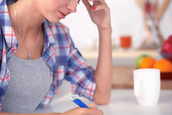 Junge Frau schreibt etwas in ihren Notizblock — Stockfoto