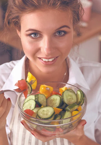 若いです女性食べる新鮮なサラダで現代的なキッチン — ストック写真